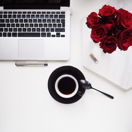 Flatlay s rudými růžemi, kávou a macbookem