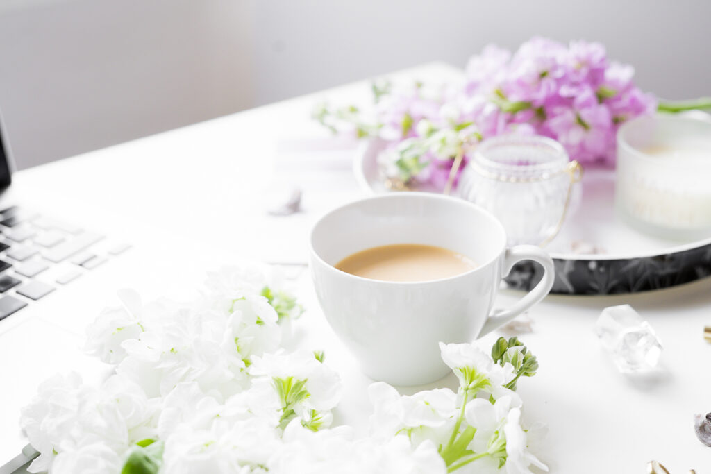 flatlay fotografie šálek kávy na stole a květiny